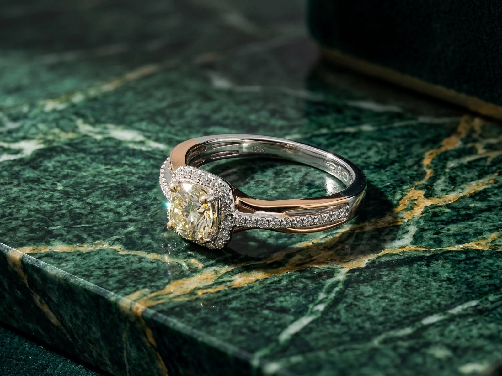 A stunning two-tone diamond engagement ring with a central cushion-cut yellow diamond surrounded by pavé-set diamonds, set in a sleek platinum and rose gold band.