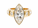 Front view of marquise diamond ring in yellow gold bezel with round and tapered baguette accent stones on white background