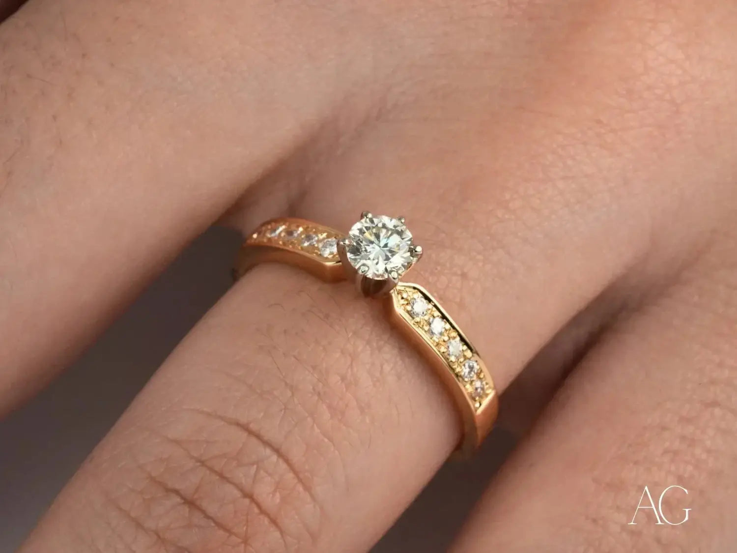 A gold engagement ring featuring a central round diamond flanked by smaller diamonds along the band exemplifies fine jewelry often associated with royal jewels in thrilling tales of lost royal jewels mysteries and rediscoveries.