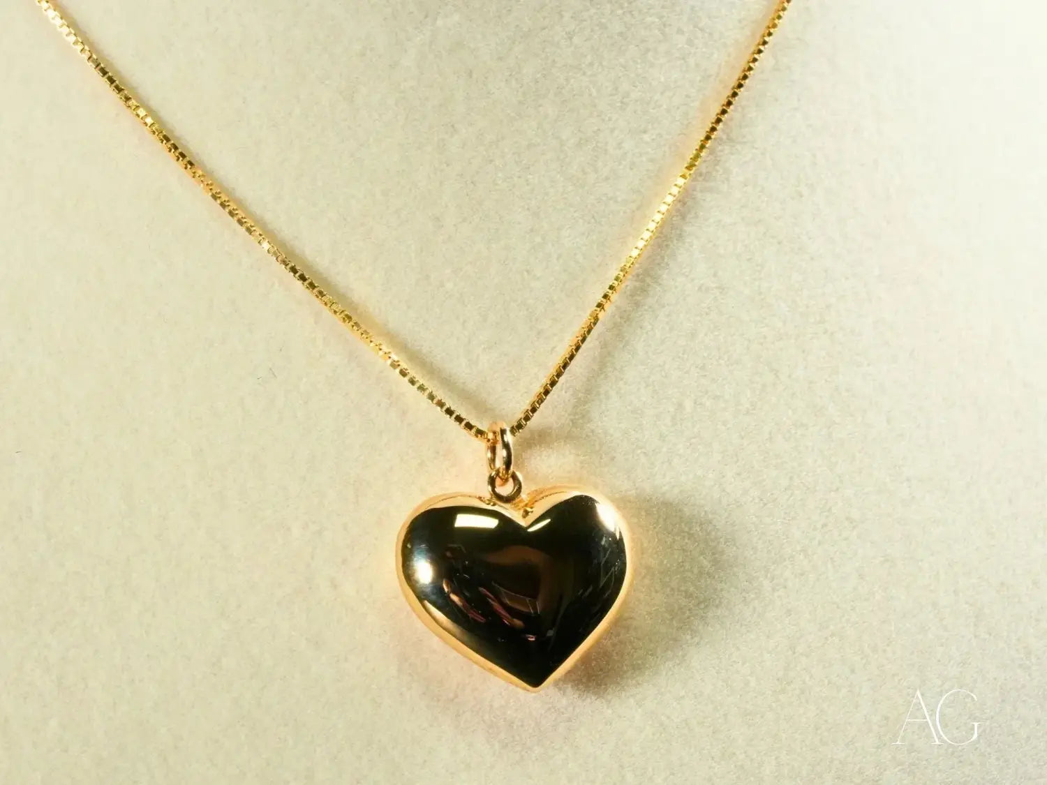 Gold heart locket pendant with black interior on chain, luxury jewelry.