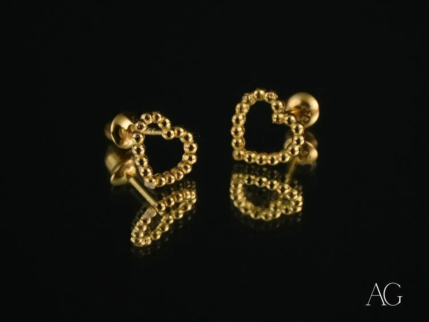 Gold heart-shaped stud earrings with a beaded outline crafted in 18k gold fine jewelry, featured in an article on gold jewelry chain styles where tradition meets contemporary elegance.