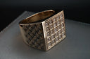 A gold ring with multiple small, square-cut diamonds set in a grid pattern.