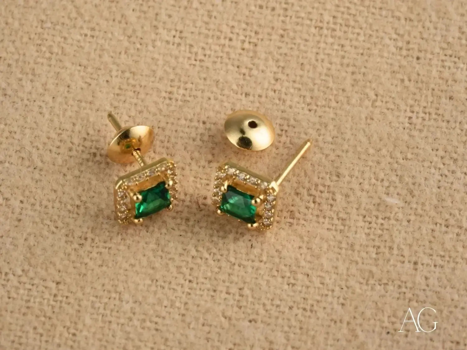 gold stud earrings featuring emerald green square gemstones surrounded by a halo of clear crystals from local everett jeweler art gold jewelry collection highlighting art gold designs in massachusetts