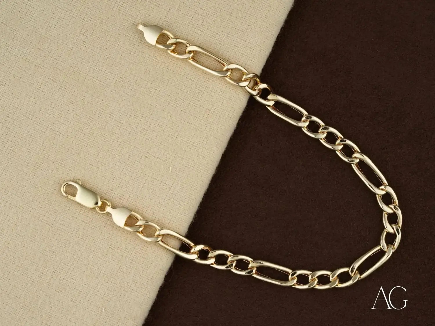 Gold-toned figaro link bracelet in art gold jewelry history