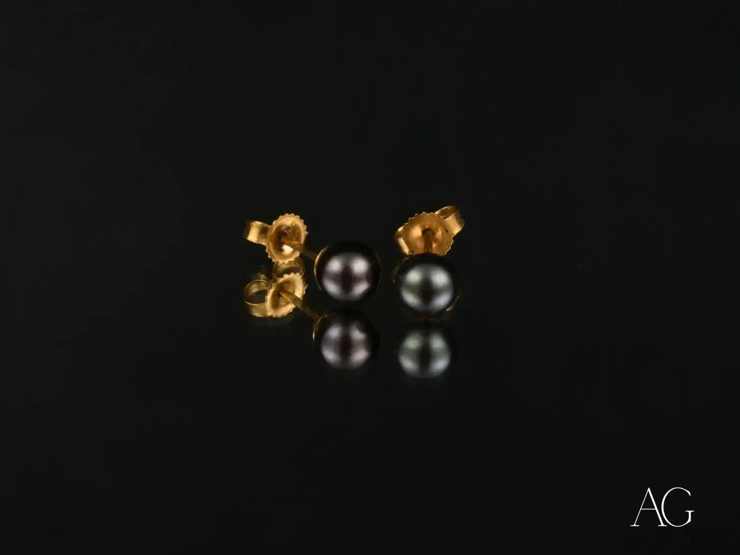 a collection of sparkling diamonds in various shapes on a black surface highlighting art gold and 18k gold jewelry