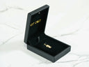 Open black jewelry box with golden charm doll pendant in art gold jewelry