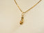 Golden flip flop pendant on a chain, showcasing art gold jewelry design