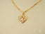 Golden H Doll gold doll pendant featuring a cutout girl figure and diamond accent
