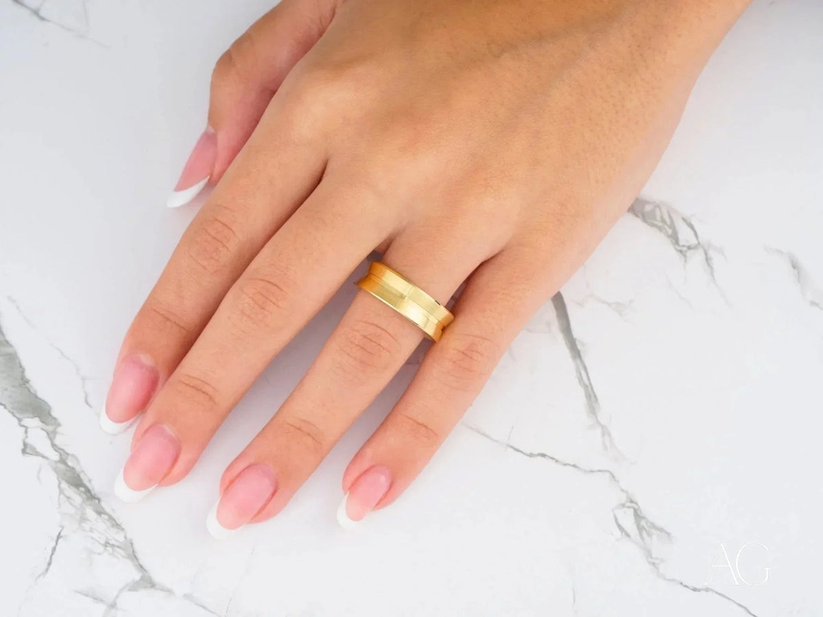 Womans hand with Golden Horizon comfort fit raised central art gold jewelry band