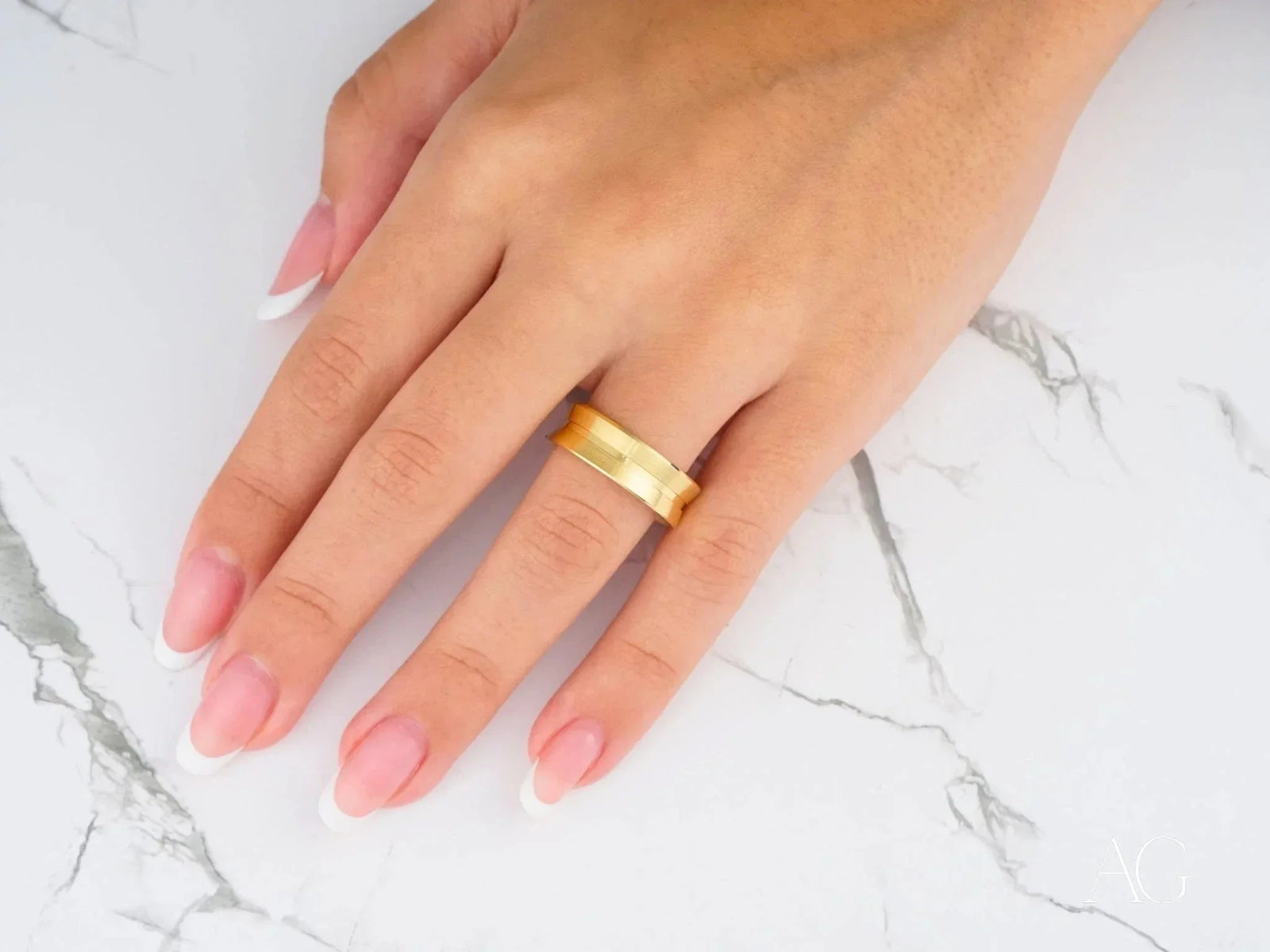 Womans hand with Golden Horizon comfort fit raised central art gold jewelry band
