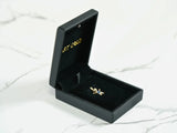 Open black jewelry box with 18k solid gold love pendant charm
