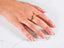 Close-up of a woman’s hand with a gold ring featuring an intricate design from the Golden Mesh Elegance collection