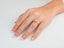 Close-up of a woman’s hand with a golden promise engagement ring in 18k gold with accented band