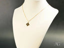 Golden puzzle pendant necklace with intricate dark brown square piece for autism awareness