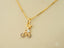 Gold pendant featuring a child on a bicycle with silver accents, part of art gold jewelry collection