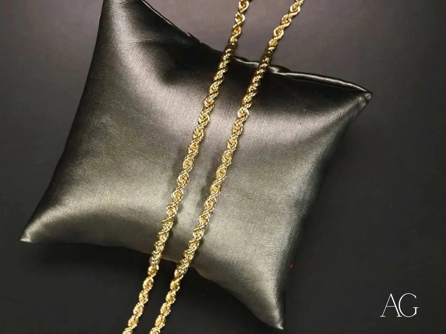 Golden rope chain necklace on black satin pillow, timeless art gold jewelry