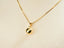 Art gold jewelry featuring a 18k solid gold golden sphere pendant on a delicate box chain