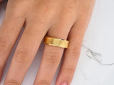 Golden Whisper wedding band with diagonal texture on finger