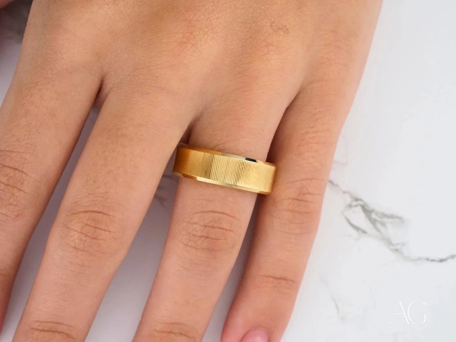 Golden Whisper wedding band with diagonal texture on finger