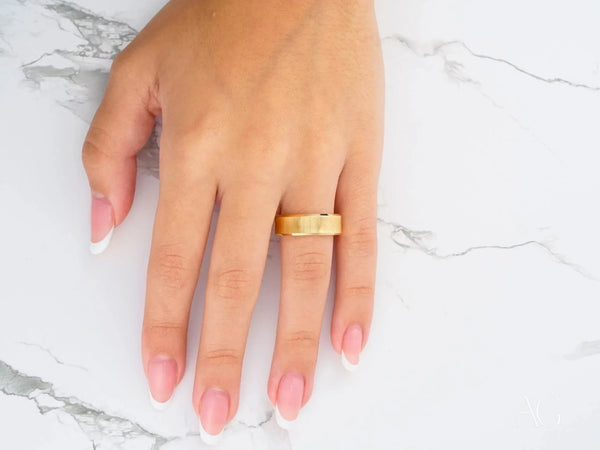 Golden Whisper art gold jewelry wedding band on womans middle finger
