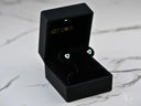 Open black velvet box with heart evil eye gold earrings