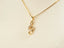 Gold treble clef necklace with cubic zirconia accents from the Harmonic Elegance Pendant collection