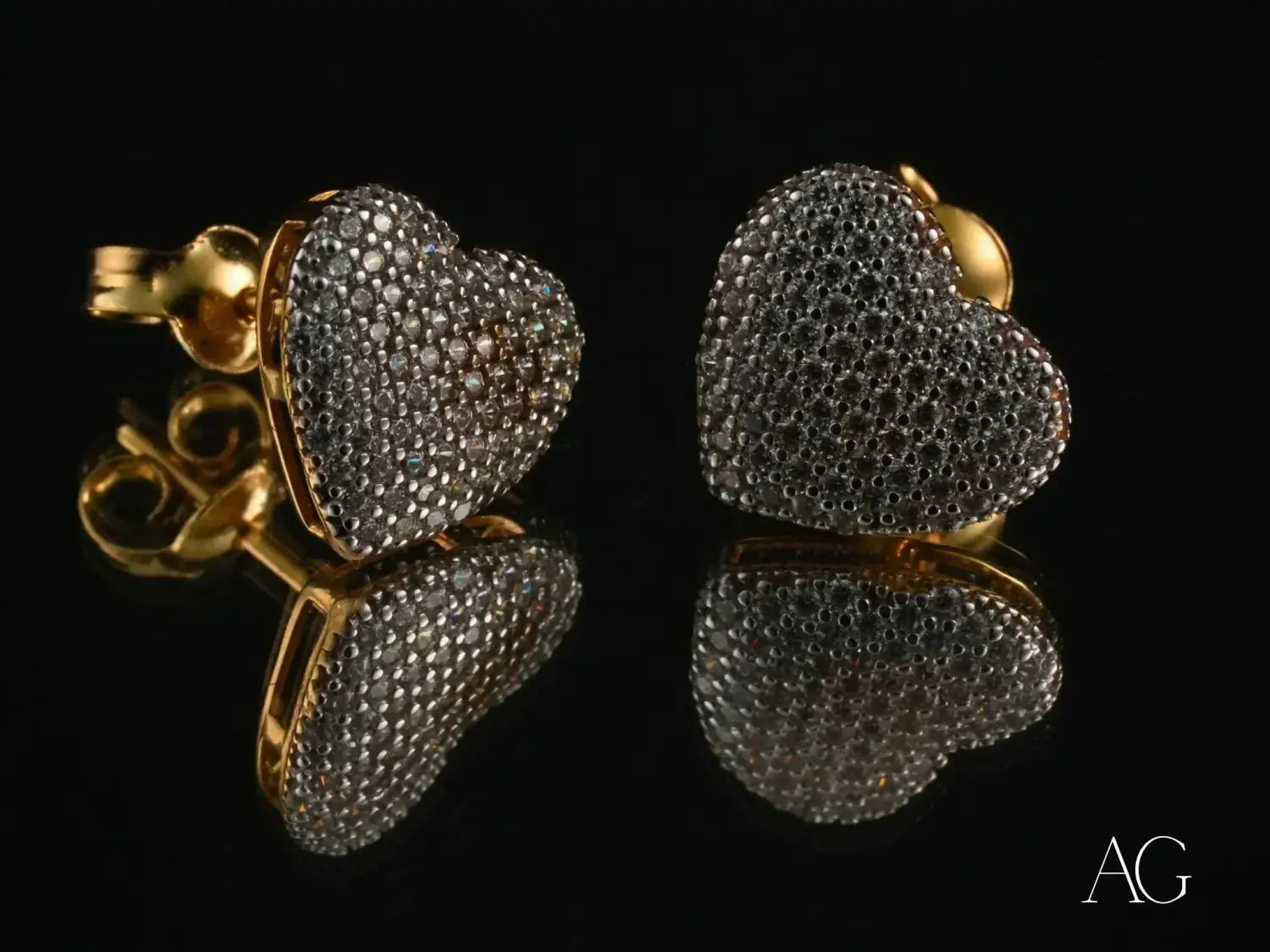 heart-shaped stud earrings with a pave setting of clear cubic zirconia stones on a polished gold-tone metal base complement fine jewelry collections featuring diamond heart motifs and gold jewelry trends.