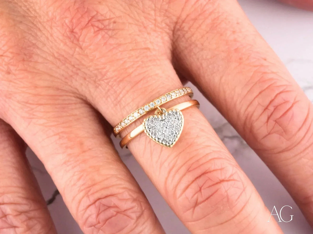 Radiant 18k gold Heart’s Glow Ring with dangling heart charm