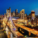 An illuminated cable-stayed bridge at dusk.