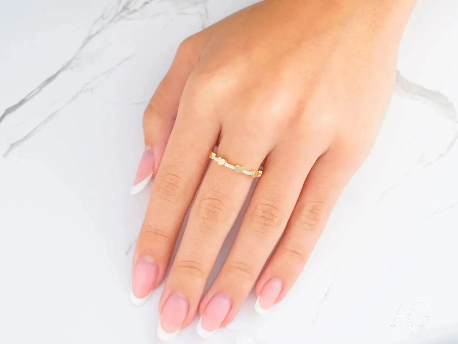 Love Elegance solid 18k yellow gold CZ heart ring on French manicured finger