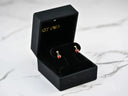 Open 18k gold ladybug earrings with red gems in black box, bring good luck