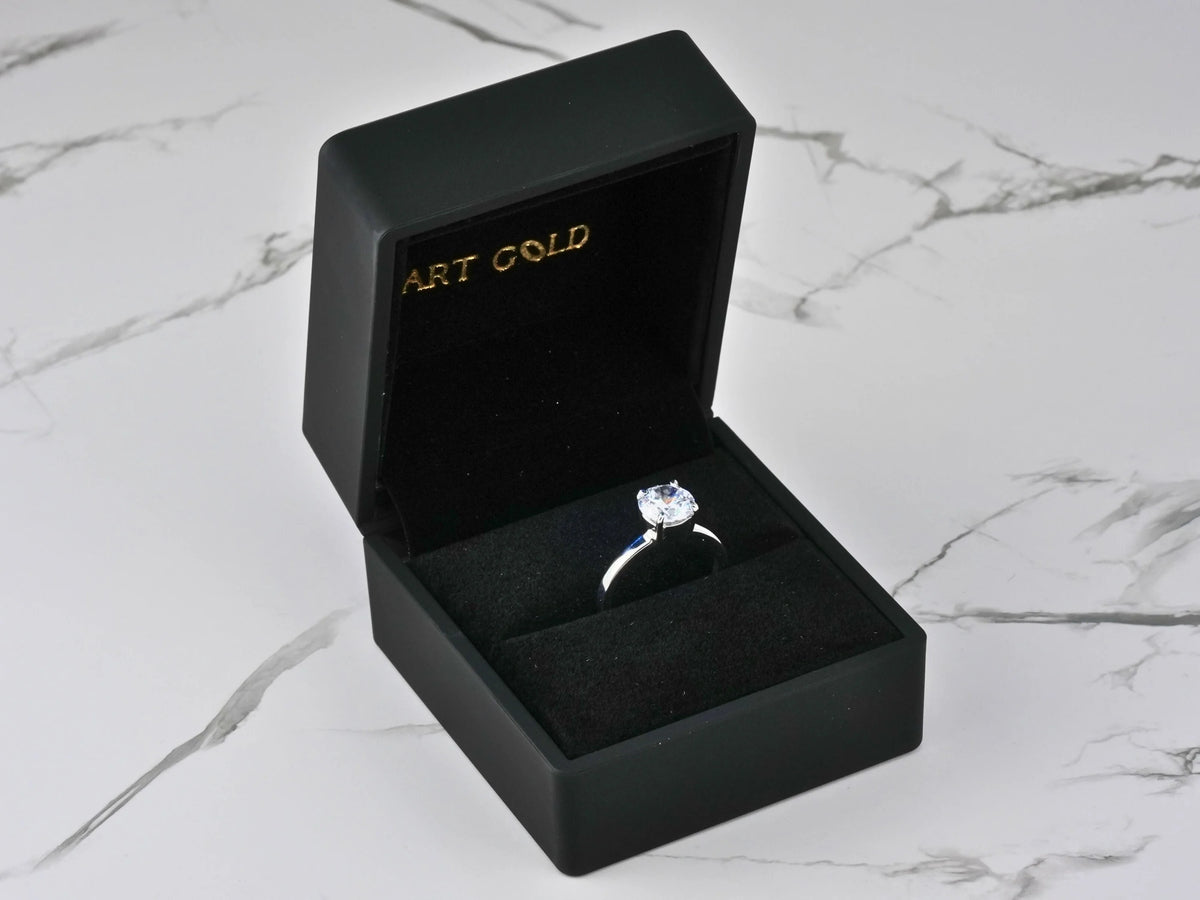 Lumina Promise Solitaire: open black box with classic four-prong silver ring and sparkling gem