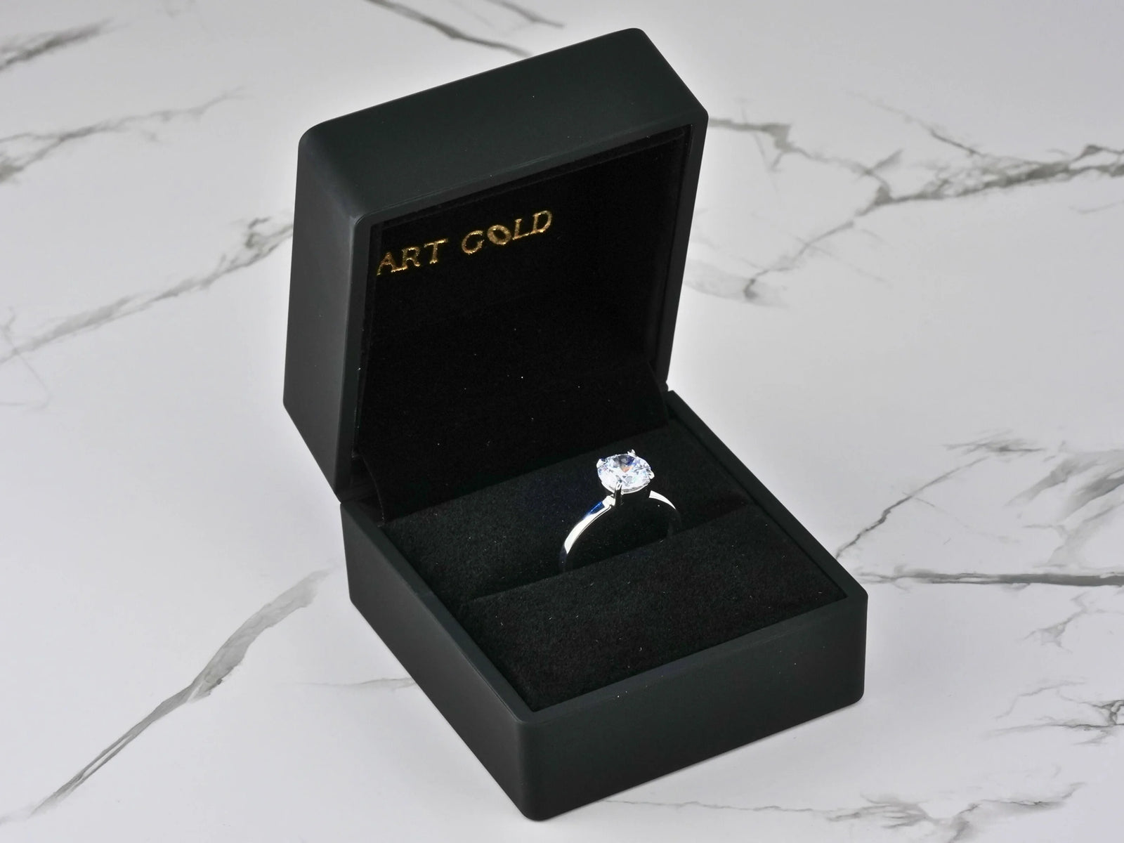 Lumina Promise Solitaire: open black box with classic four-prong silver ring and sparkling gem