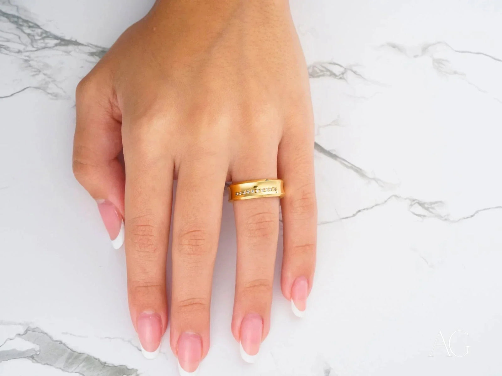 Top view of gold wedding band with linear diamond row and polished finish