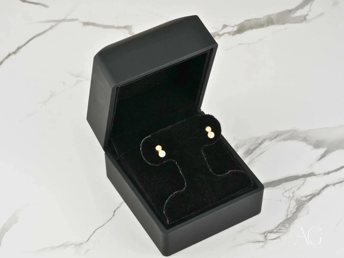 Open black jewelry box with Lustrous Harmony 18K gold pearl drop earrings