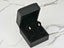 Open black jewelry box with Lustrous Harmony 18K Gold Pearl Drop Earrings on velvet stand