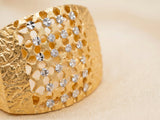 Macro detail of 18K gold honeycomb lattice ring showing white gold accents within hexagonal openings