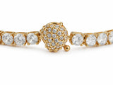 Close view of the spherical clasp, its dome pave-set with small stones under a polished gold cap, joined by pin links to the row of larger four-prong stones