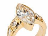 Marquise diamond ring in yellow gold bezel with round accent stone, angled close-up showing faceting and setting details