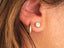 Art gold jewelry featuring 18k yellow gold gold mini hoops and a diamond stud