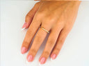 Womans hand with modern square shape solid 18k yellow gold ring on finger