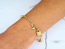 Exquisite 18k gold charm bracelet with nautical elegance, anchor and handbag charms