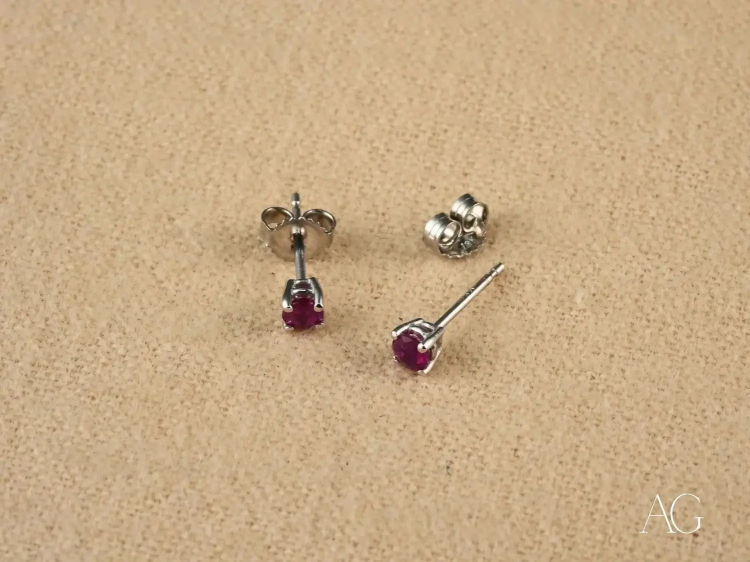 a pair of elegant stud earrings featuring vibrant red rubies set in silver-toned metal with a classic four-prong design, reminiscent of fine jewelry and gold jewelry styles discussed in lost royal jewels mysteries and ceremonies