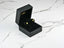 Open black jewelry box showcasing Peridot Radiance 18k Gold Pear-Shaped Earrings art gold jewelry