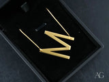 Gold zig-zag dangle earrings in black box with personalized necklace