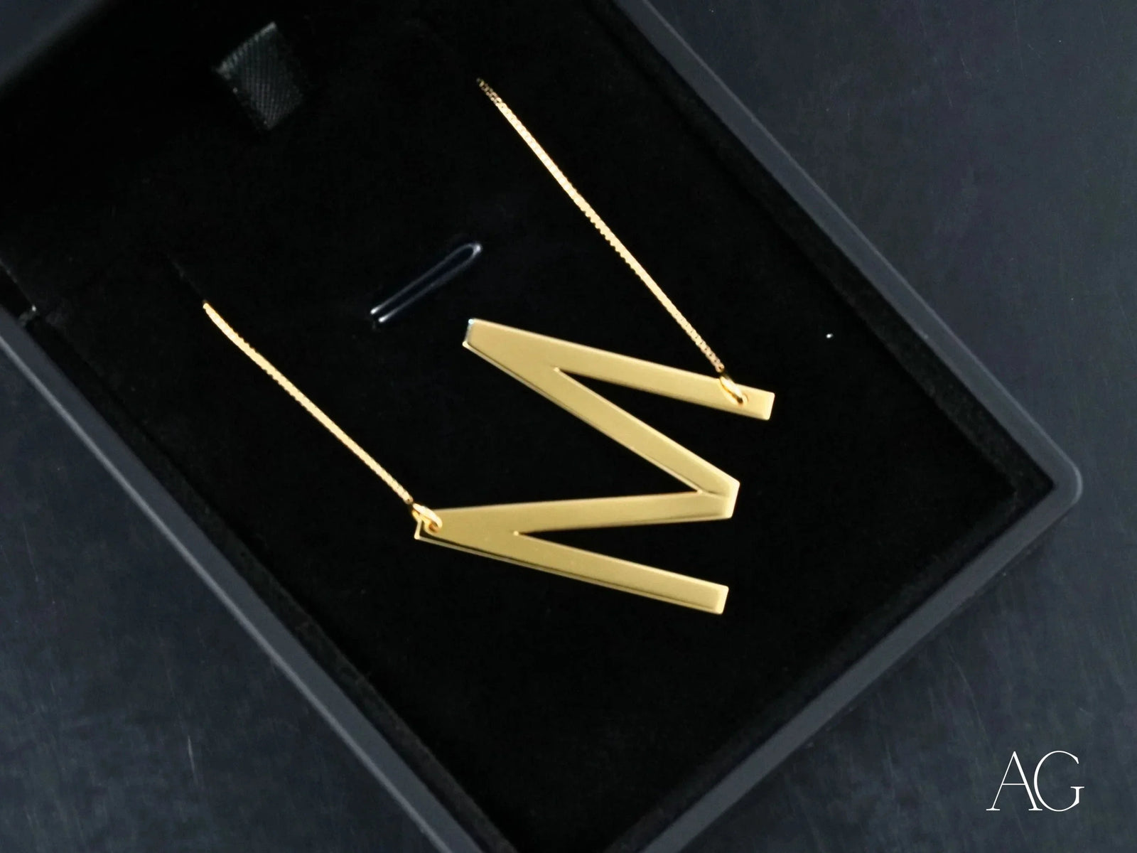 Gold zig-zag dangle earrings in black box with personalized necklace