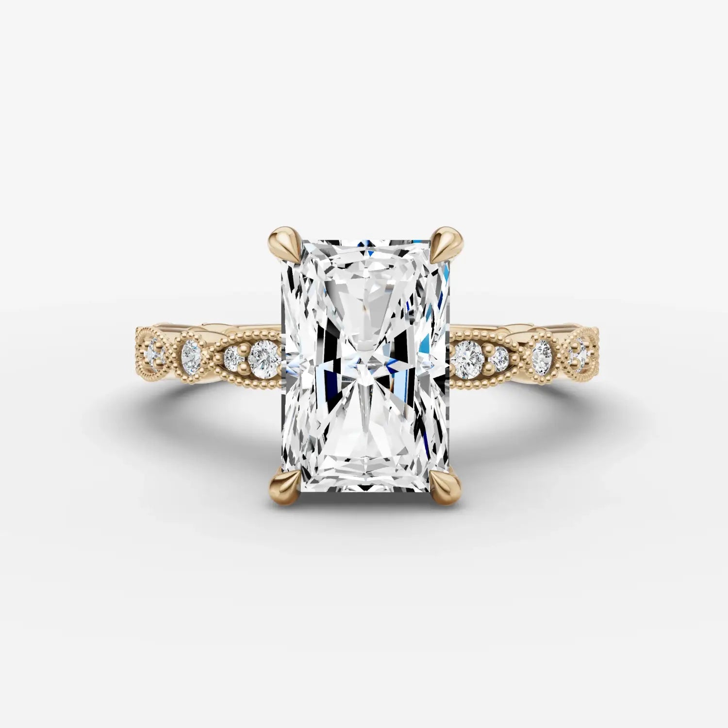 A radiant emerald-cut diamond engagement ring with pavé diamonds on a yellow gold band from everett jewelry store.