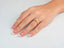 Hand wearing Radiant Vow Engagement Ring with split shank design in 18k yellow gold