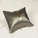 18k gold ID bracelet with crown motif on grey pillow