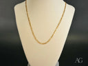 Regal Prestige 18K yellow gold Figaro chain on cream stand